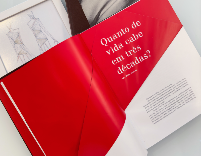Livro com páginas vermelhas e brancas em cima de uma mesa.